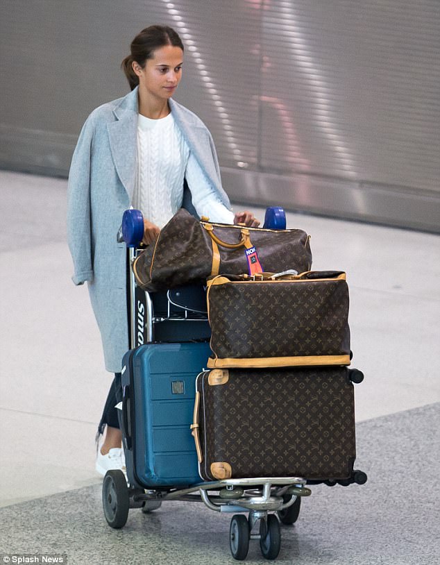 Alicia Vikander shows off her wedding ring as she arrives in Miami without  new husband Michael Fassbender